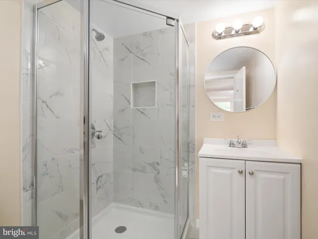 a bathroom with a shower a mirror and a sink