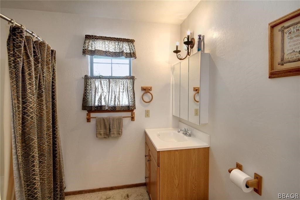 650 Riverside Avenue Sugarloaf, CA 92386 - Photo 8 of 15 a bathroom with a shower a sink and mirror