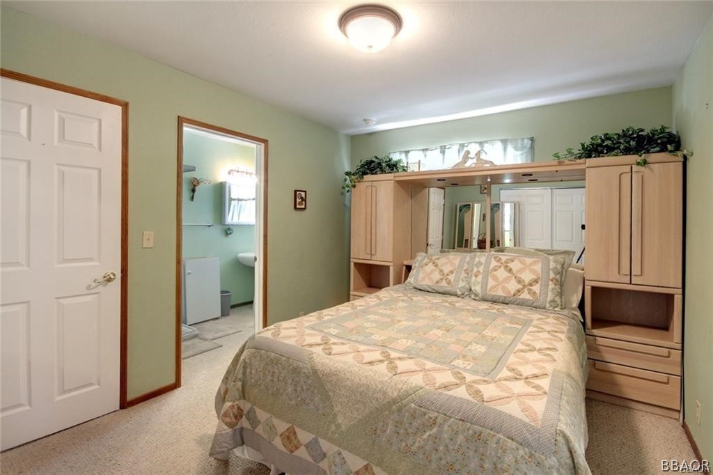 650 Riverside Avenue Sugarloaf, CA 92386 - Photo 10 of 15 a bedroom with a large bed and a chandelier