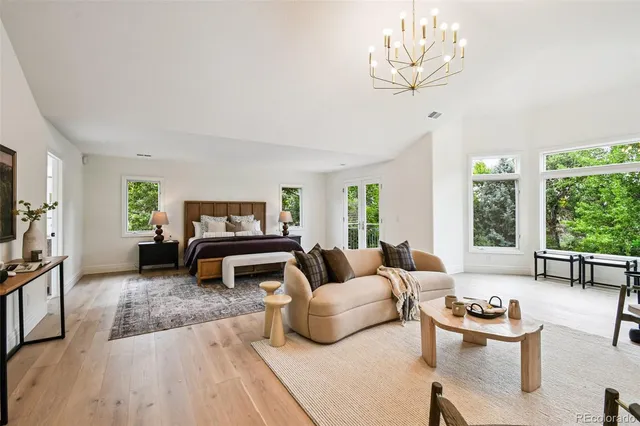 a living room with furniture chandelier and a flat screen tv