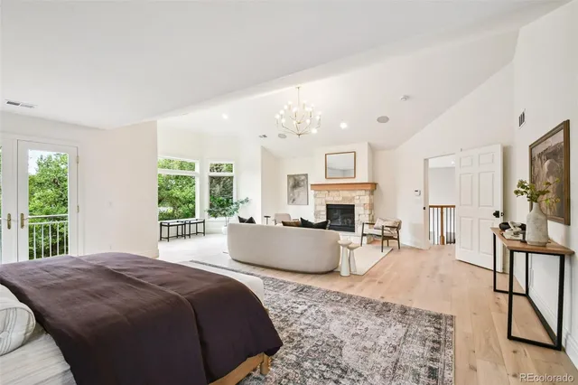 a large bedroom with a large bed a flat tv screen and a fireplace