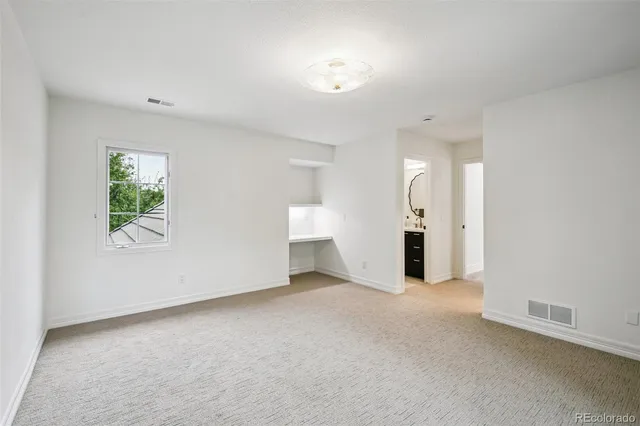 an empty room with a window and a bathroom