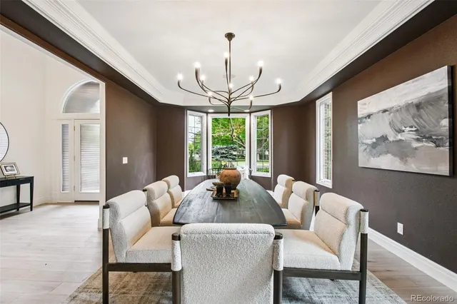 a dining room with furniture a chandelier and window