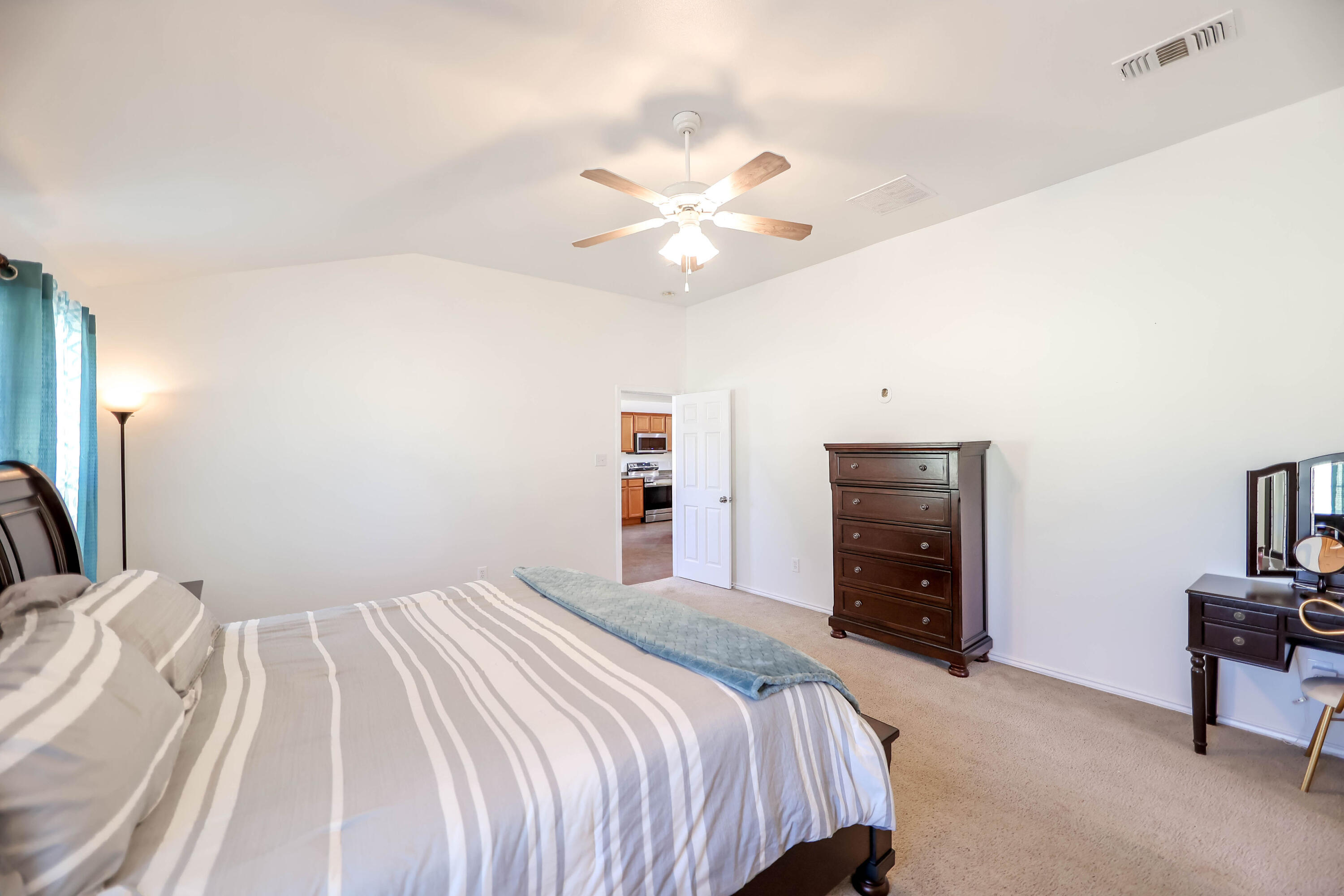 6718 92nd Street Lubbock, TX 79424 - Photo 14 of 31 a bedroom with a bed and a chandelier