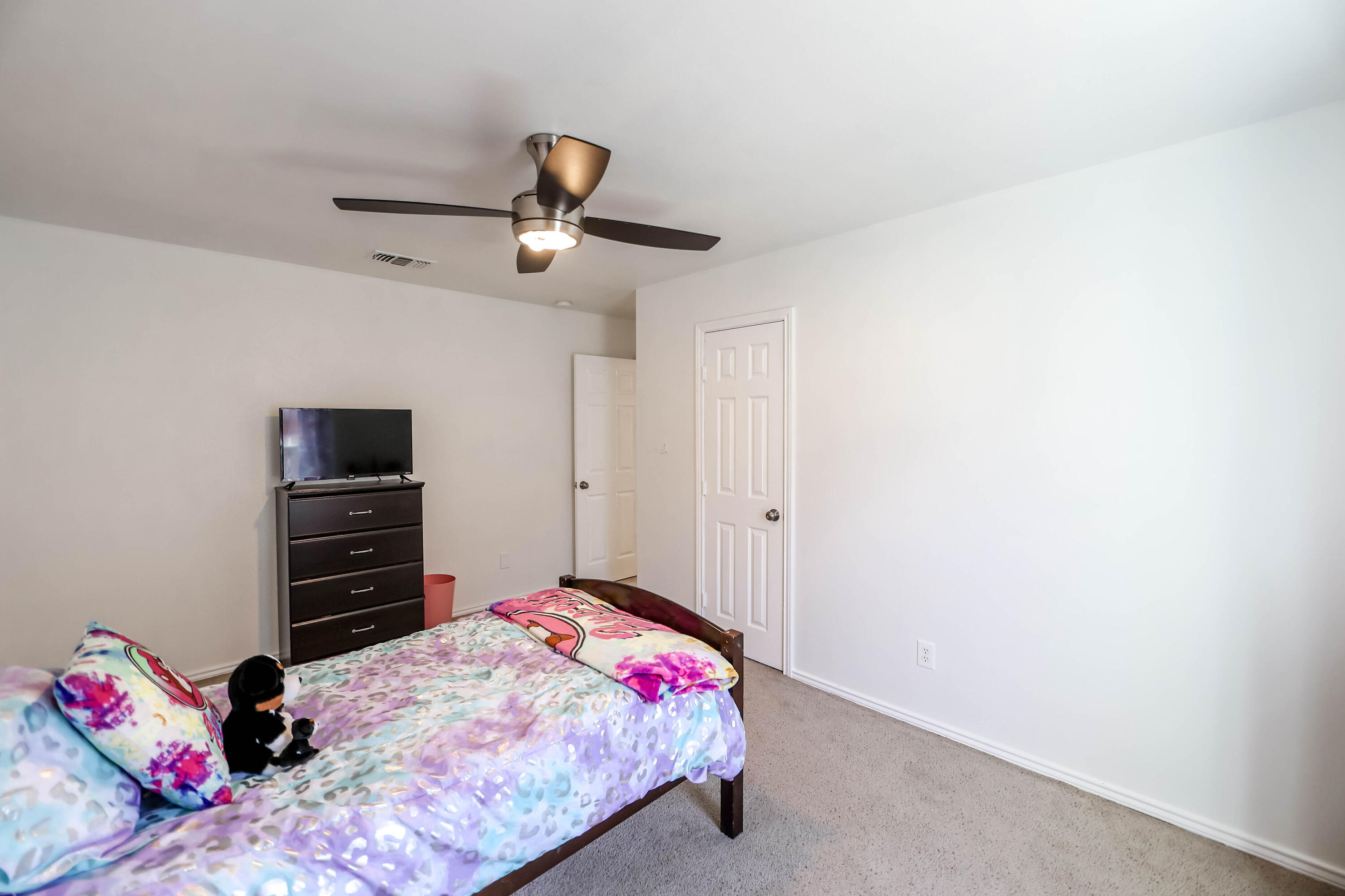 6718 92nd Street Lubbock, TX 79424 - Photo 20 of 31 a bedroom with a bed and a flat screen tv