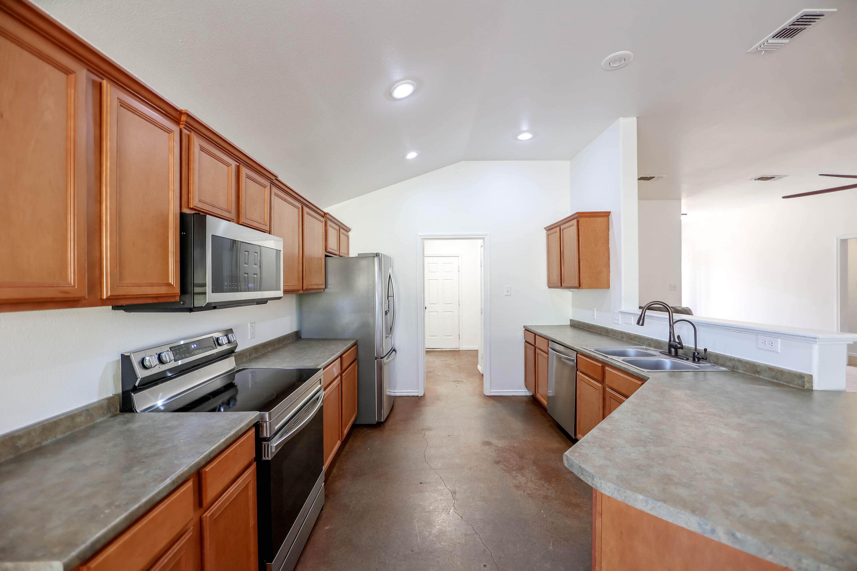 6718 92nd Street Lubbock, TX 79424 - Photo 21 of 31 a kitchen with stainless steel appliances granite countertop a sink stove and refrigerator