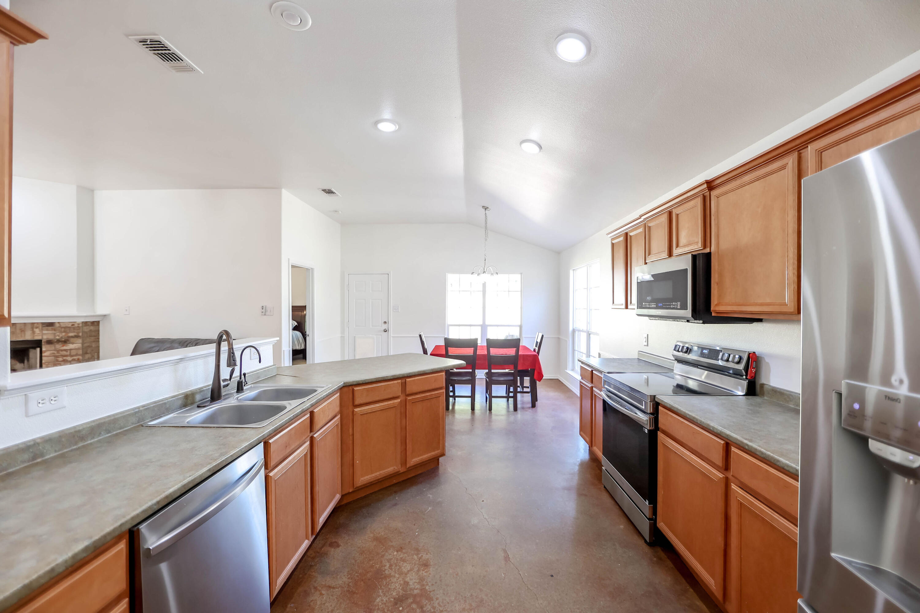 6718 92nd Street Lubbock, TX 79424 - Photo 10 of 31 a large kitchen with stainless steel appliances granite countertop a sink stove and refrigerator
