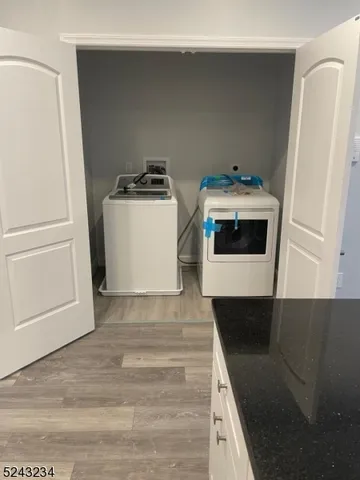 a utility room with wooden floor washer and dryer