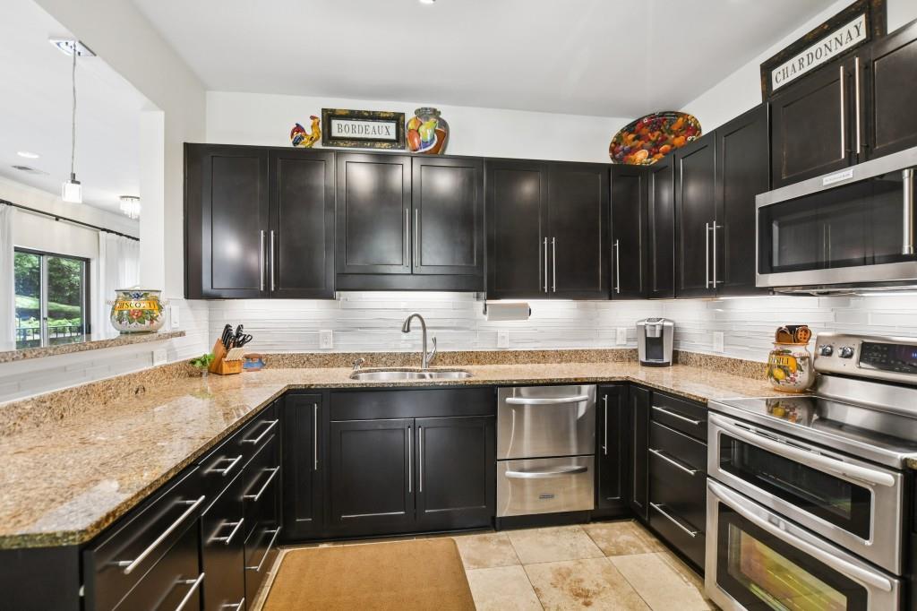 2921 Lenox Road Northeast, Unit 103 Atlanta, GA 30324 - Photo 12 of 37 a kitchen with stainless steel appliances a sink stove and cabinets