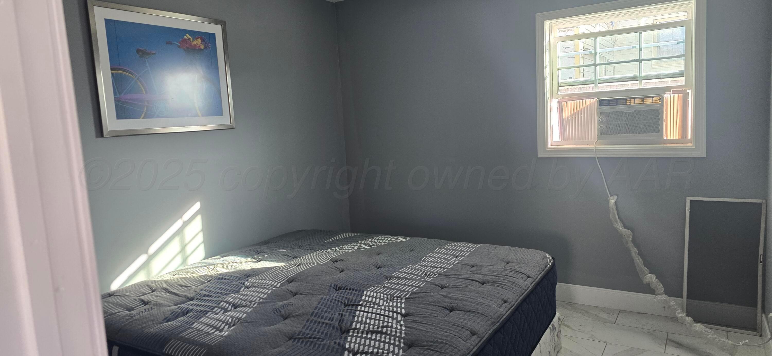 904 Elmore Street Borger, TX 79007 - Photo 17 of 20 a bedroom with a bed and a window