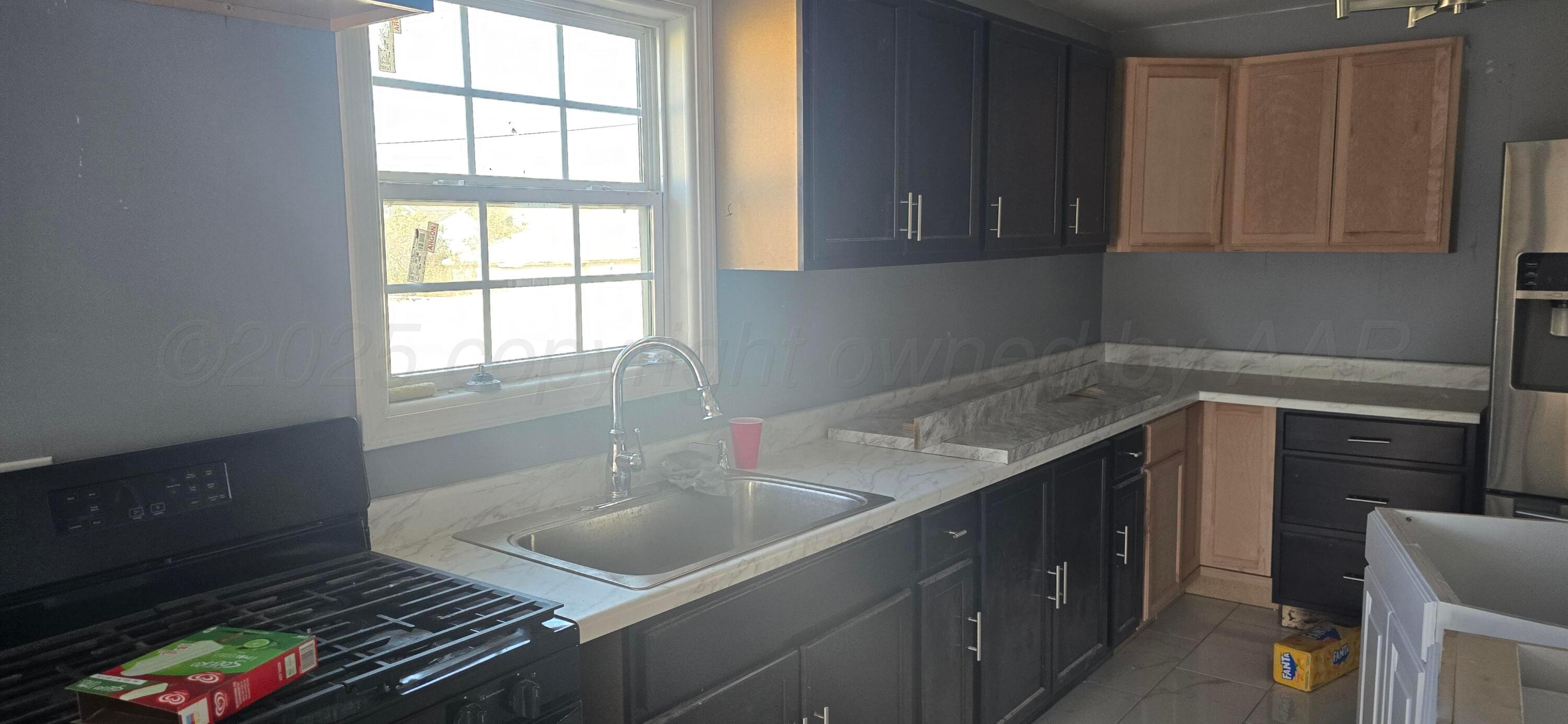 904 Elmore Street Borger, TX 79007 - Photo 6 of 20 a kitchen with a sink and cabinets