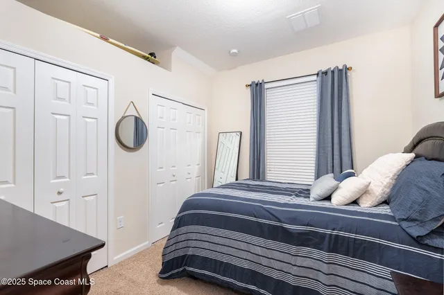 a bedroom with a bed a mirror and a window