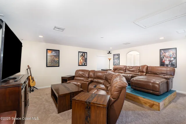 a living room with furniture a flat screen tv and a window