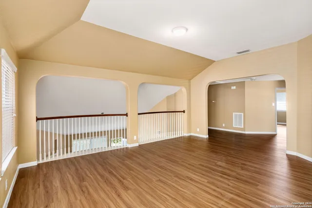 a view of empty room with wooden floor