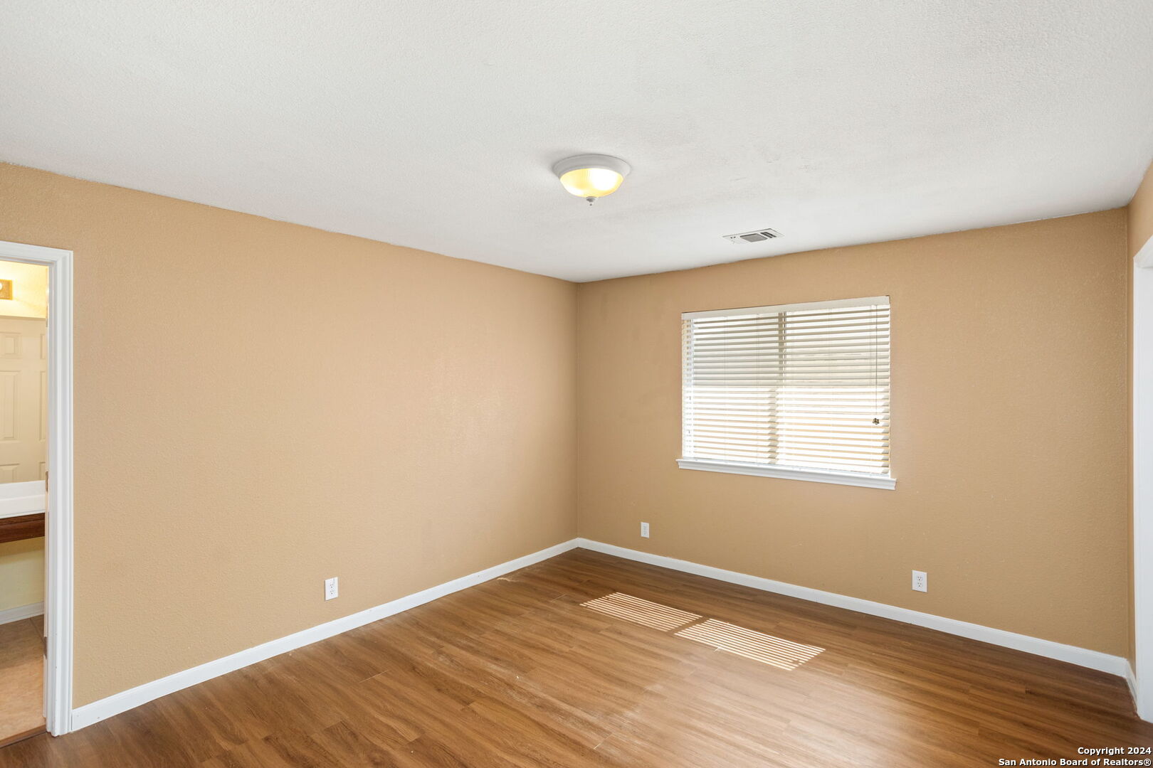 3415 Highline Trail San Antonio, TX 78261 - Photo 16 of 24 a view of an empty room with wooden floor and a window