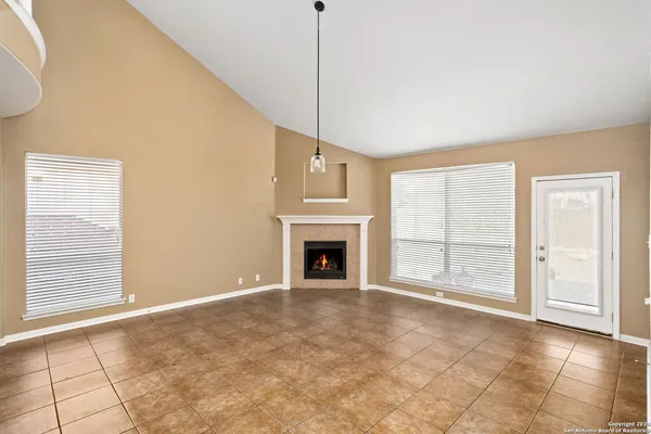 a view of an empty room with a fireplace and a window