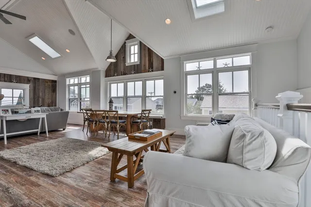 a living room with furniture wooden floor and a large window