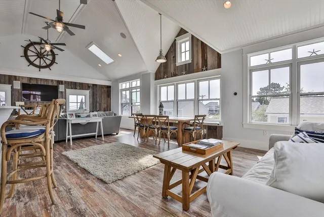 a living room with furniture a fireplace and large windows
