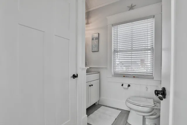 a bathroom with a toilet a sink and a window