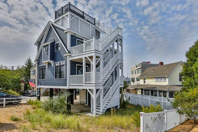 a view of a big house with large windows and a small yard