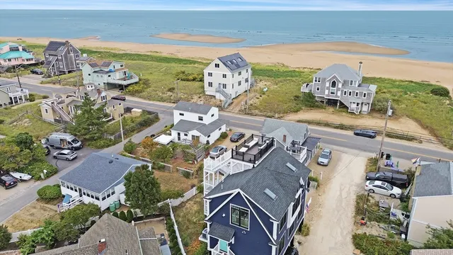 an aerial view of a house with garden space and ocean view