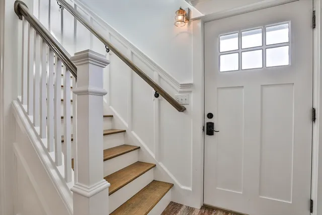 a view of staircase with wooden floor and white walls