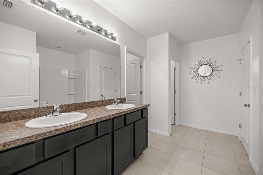 3902 Southeast 99th Street Belleview, FL 34420 - Photo 16 of 28 a bathroom with a granite countertop double vanity and a mirror