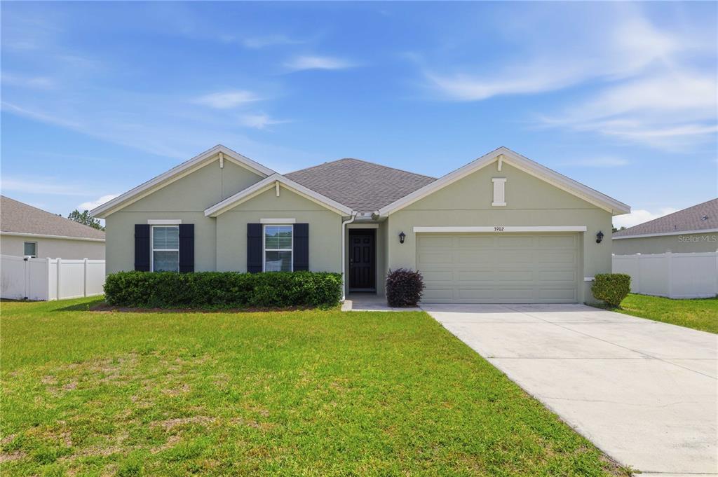 3902 Southeast 99th Street Belleview, FL 34420 - Photo 2 of 28 a front view of a house with a yard and garage