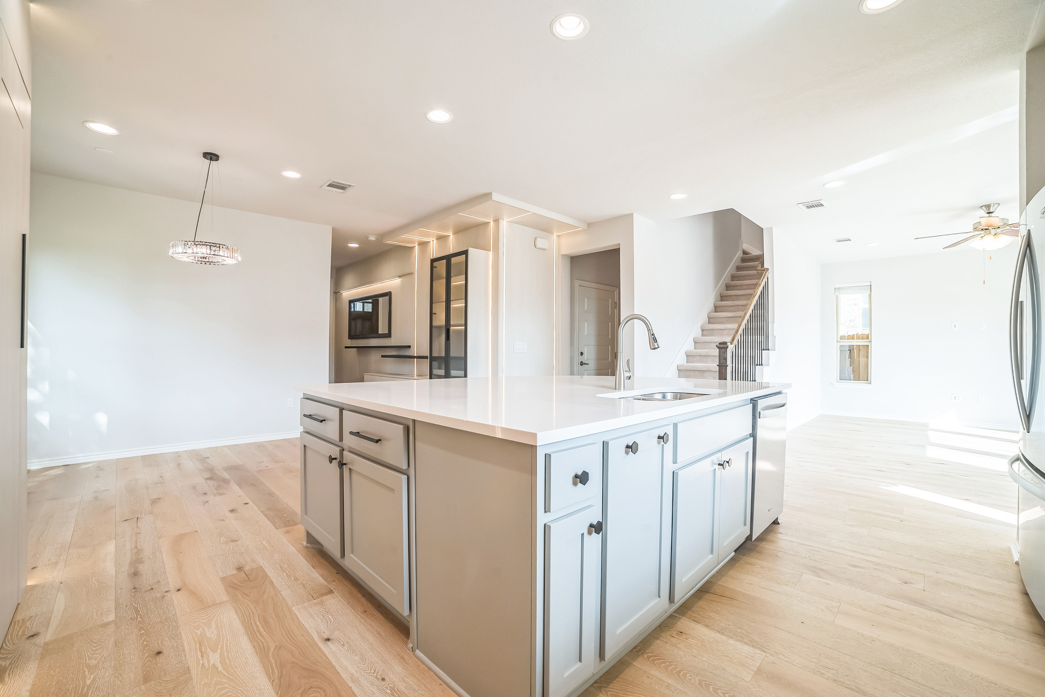 14300 McCoy Loop, Unit 21 Austin, TX 78717 - Photo 12 of 40 Open concept kitchen and living area featuring light-colored hardwood floors, recessed lighting, and an island with a sink and light-colored cabinetry