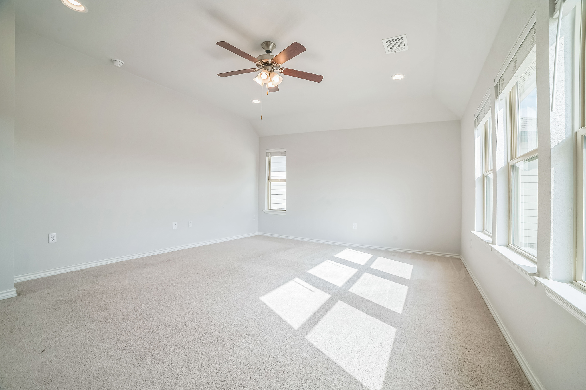 14300 McCoy Loop, Unit 21 Austin, TX 78717 - Photo 17 of 40 Bright and spacious room featuring carpeted flooring, a ceiling fan with integrated lighting, recessed lighting, and large windows providing abundant natural light
