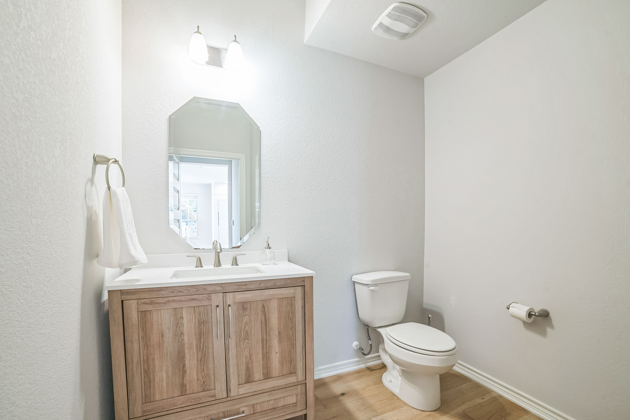 14300 McCoy Loop, Unit 21 Austin, TX 78717 - Photo 27 of 40 Bathroom featuring a wooden vanity with a white countertop and an octagonal mirror
