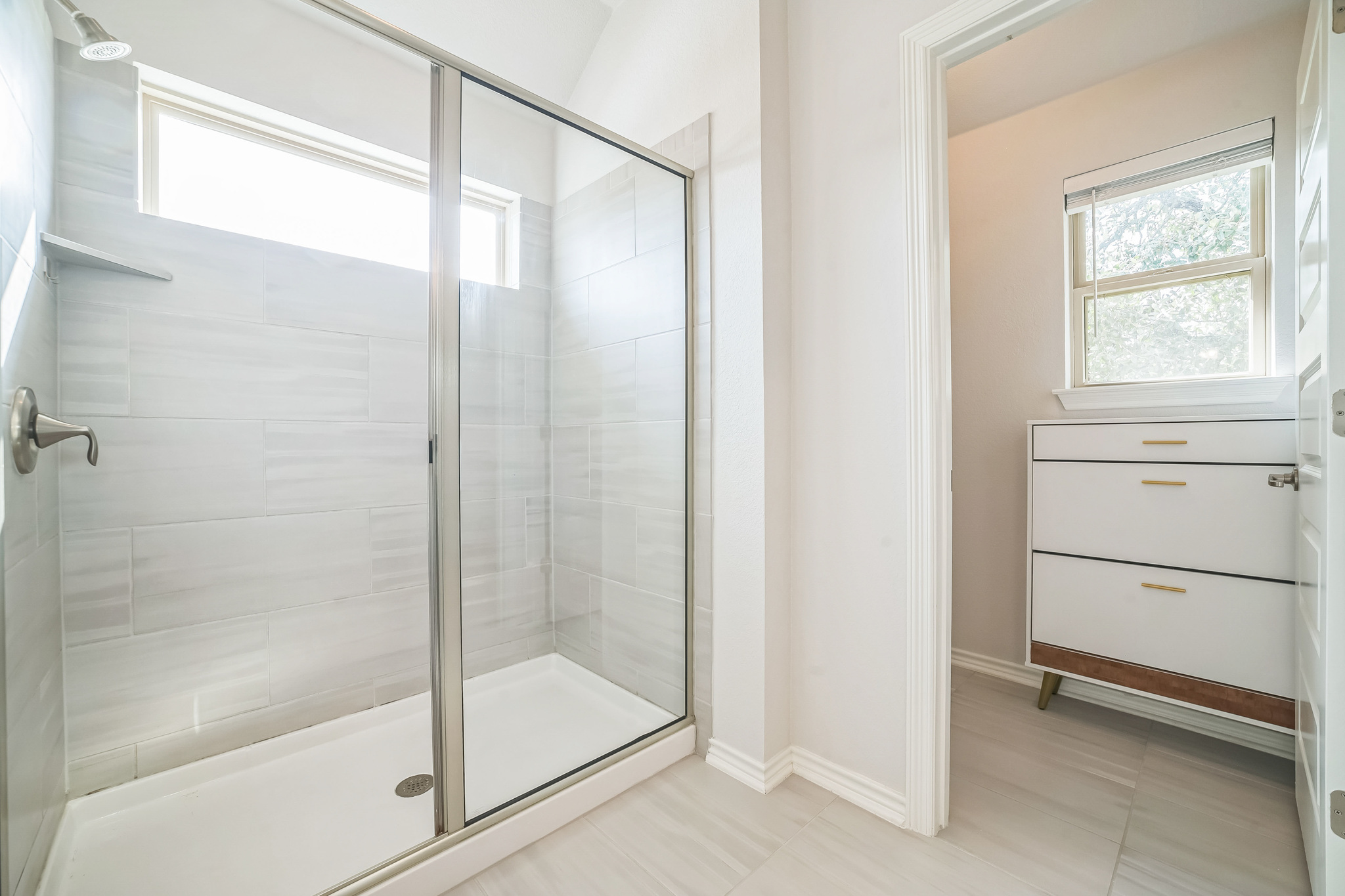 14300 McCoy Loop, Unit 21 Austin, TX 78717 - Photo 28 of 40 The bathroom features a spacious glass-enclosed shower with light-toned tiled walls and a built-in shelf