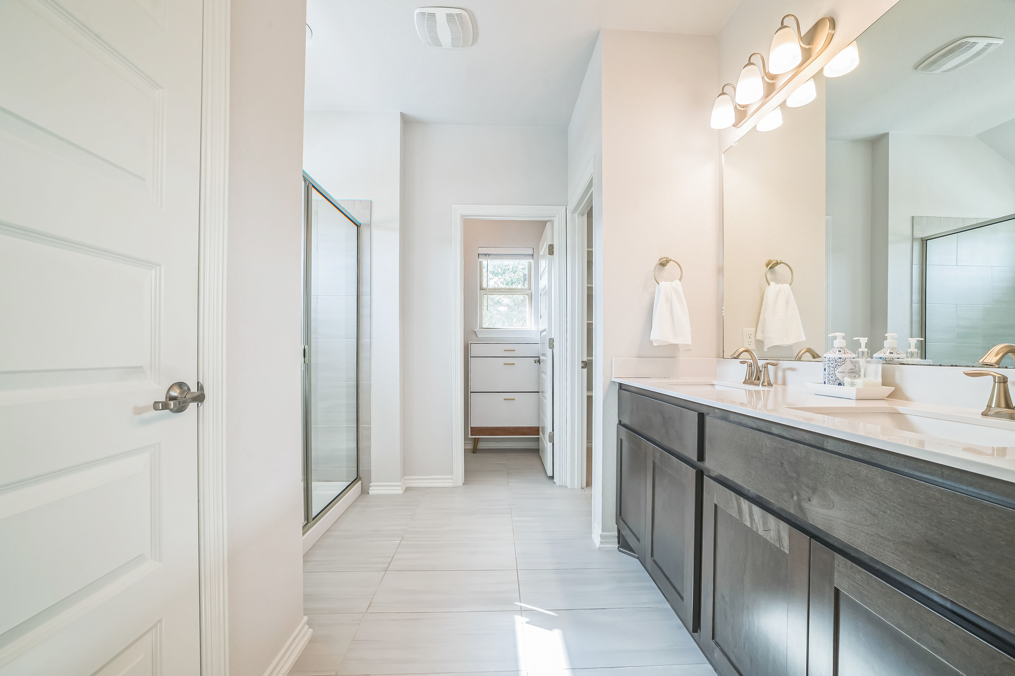 14300 McCoy Loop, Unit 21 Austin, TX 78717 - Photo 32 of 40 The bathroom features a double vanity with two sinks, a large mirror, and ample storage cabinetry