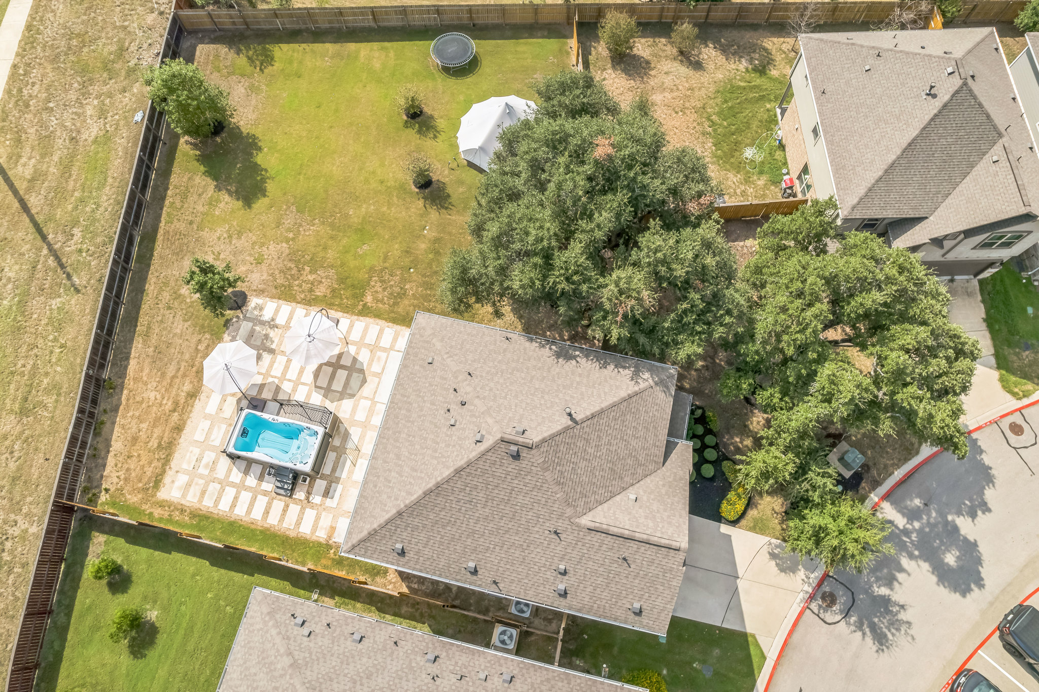 14300 McCoy Loop, Unit 21 Austin, TX 78717 - Photo 38 of 40 Aerial view of the property showing a private outdoor patio with a spa and two umbrellas
