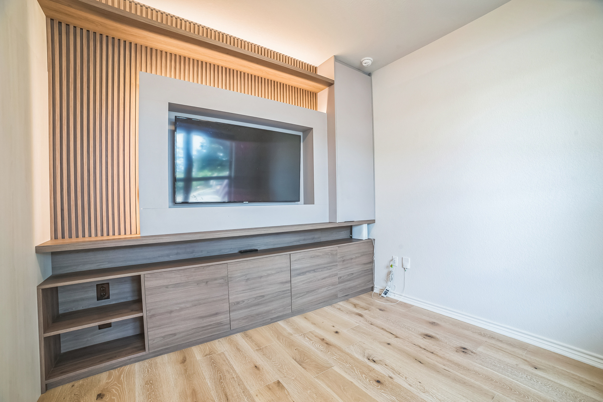 14300 McCoy Loop, Unit 21 Austin, TX 78717 - Photo 6 of 40 This room features a built-in media console with wood paneling and integrated shelving, complemented by light-toned flooring