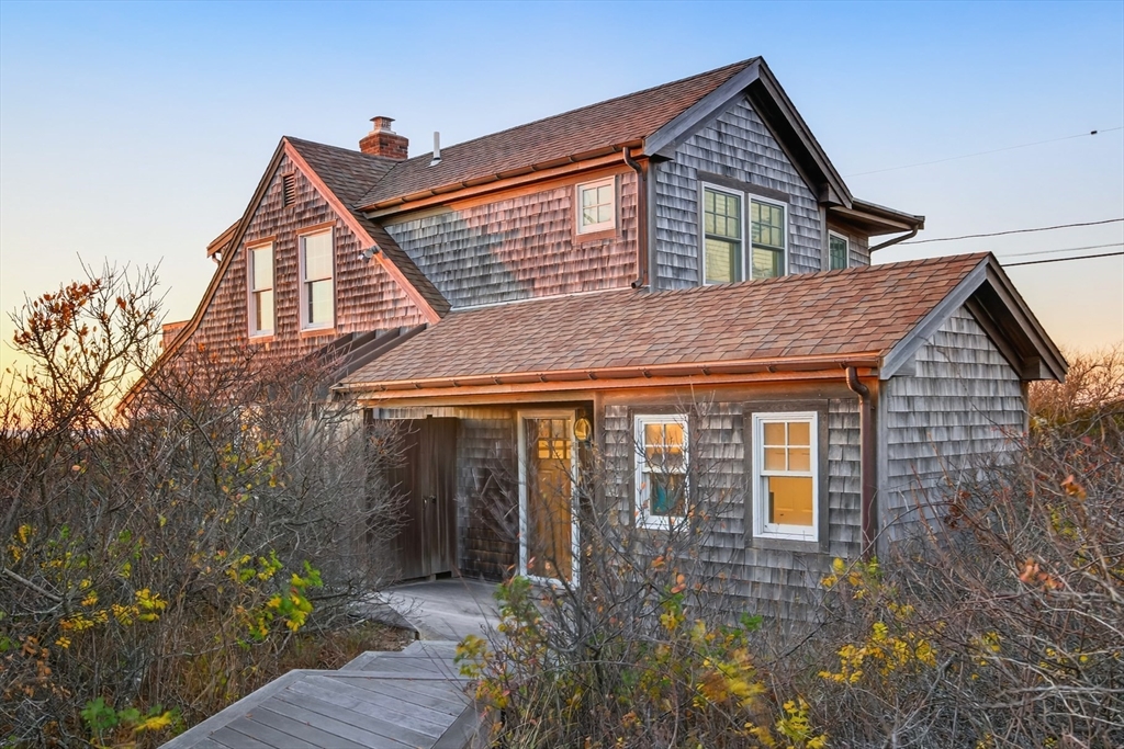 1145 Kingsbury Beach Road Eastham, MA 02642 - Photo 9 of 42 a front view of a house with a yard