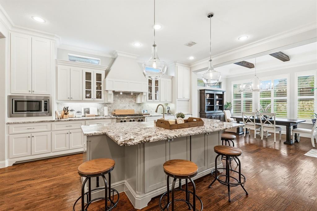 6721 Oak Knoll Road Flower Mound, TX 76226 - Photo 4 of 40 This kitchen is the heart of the home, offering extensive prep space, seating, and designer pendant lighting.