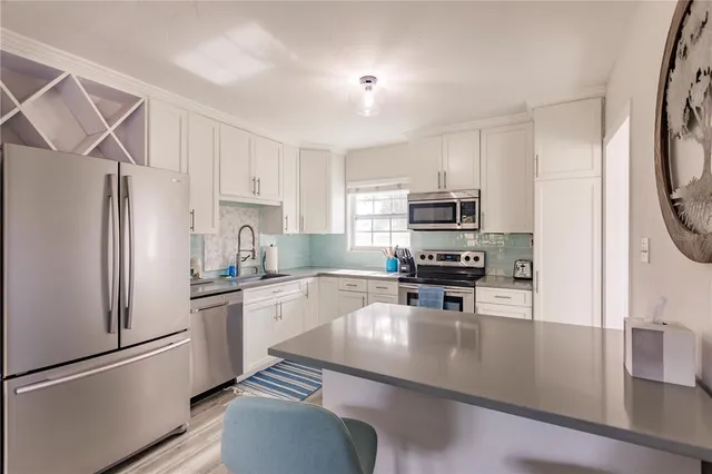 a kitchen with granite countertop a refrigerator stove and sink