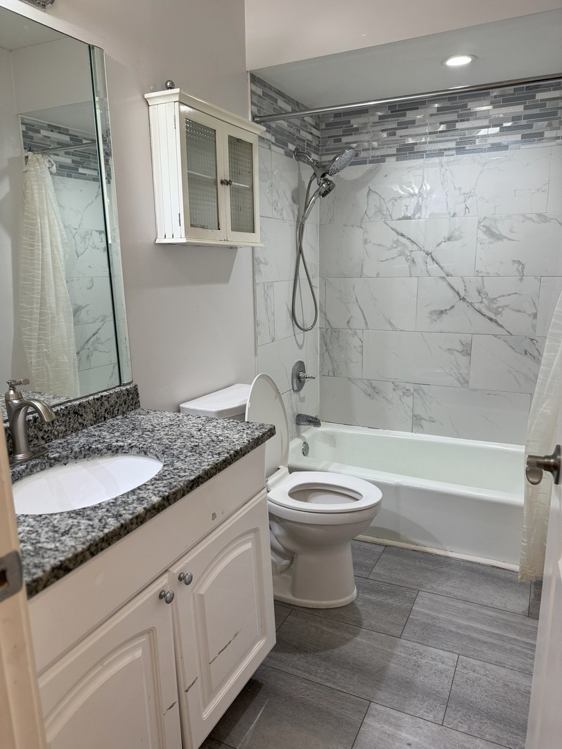 6027 103rd Street, Unit 1A Chicago Ridge, IL 60415 - Photo 9 of 22 a bathroom with a granite countertop toilet sink and shower
