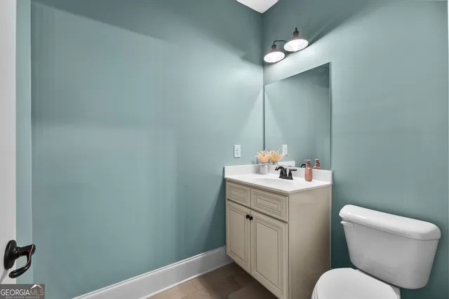 a bathroom with a toilet sink and mirror