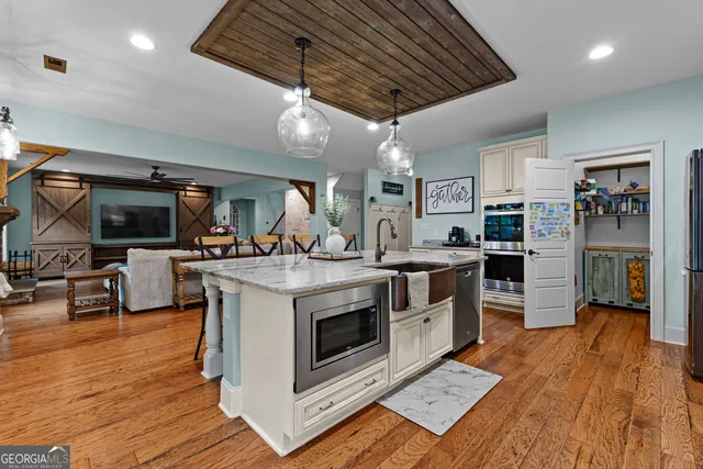 a kitchen with stainless steel appliances kitchen island granite countertop a stove and a refrigerator