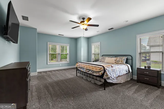 a bedroom with a large bed and a flat screen tv