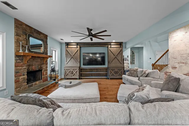 a living room with furniture a flat screen tv and a fireplace