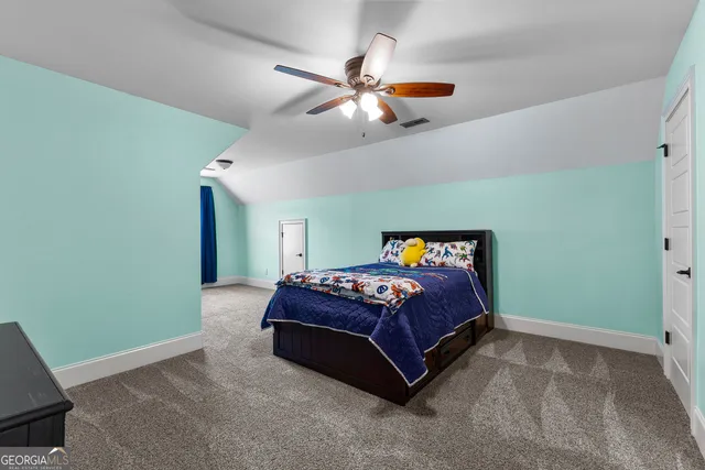 a spacious bedroom with a bed and a chandelier