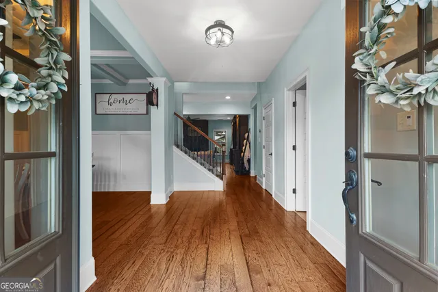 a view of a hallway with wooden floor and staircase