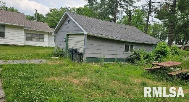 a backyard of a house with plants and large trees