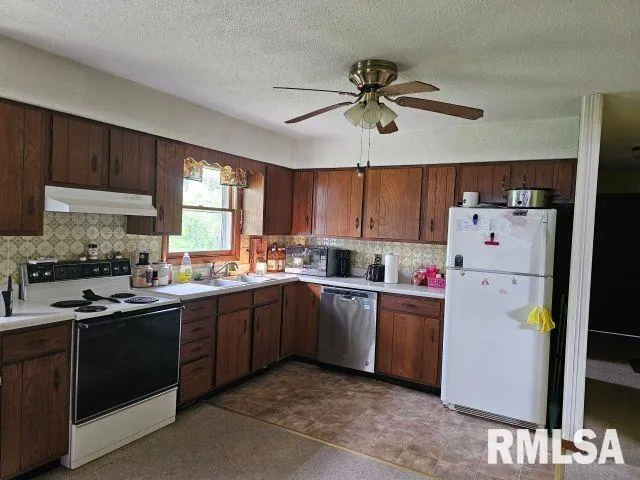 a kitchen with a sink a refrigerator and cabinets
