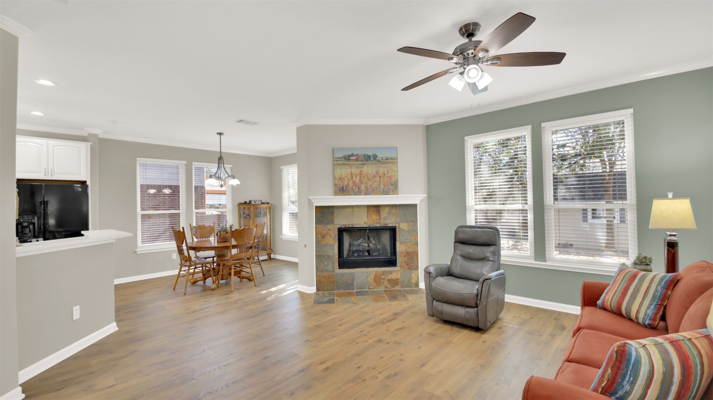1210 Mathias Street Cedar Park, TX 78613 - Photo 5 of 31 Living area with crown molding, light wood-type flooring, a fireplace, ceiling fan, and healthy amount of natural light