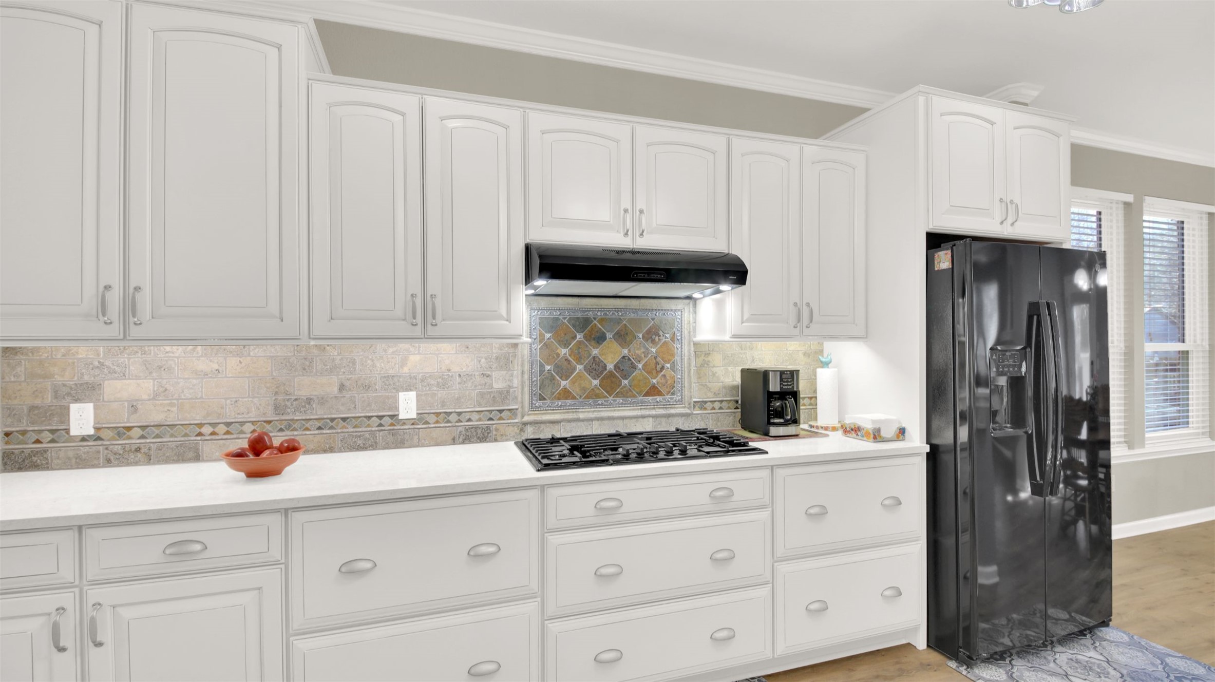 1210 Mathias Street Cedar Park, TX 78613 - Photo 9 of 31 Kitchen featuring white cabinetry, black fridge with ice dispenser, tasteful backsplash, ornamental molding, and light stone countertops
