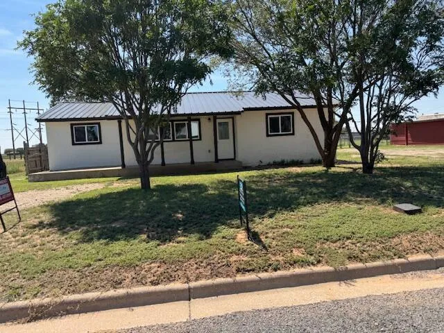 a front view of a house with a yard and trees
